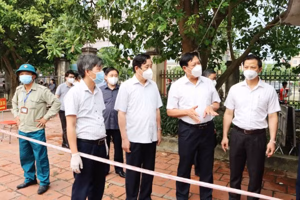 Thứ trưởng Bộ Y tế Đỗ Xuân Tuyên (thứ 2 từ phải sang) và Phó Chủ tịch Thường trực UBND tỉnh Vương Quốc Tuấn (ngoài cùng bên phải) kiểm tra việc lấy mẫu xét nghiệm Covid-19.