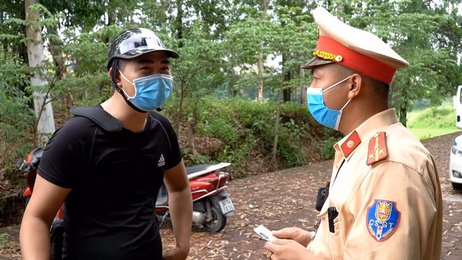 Lực lượng CSGT tuyên truyền nhắc nhở người tham gia giao thông phòng dịch Covid-19.