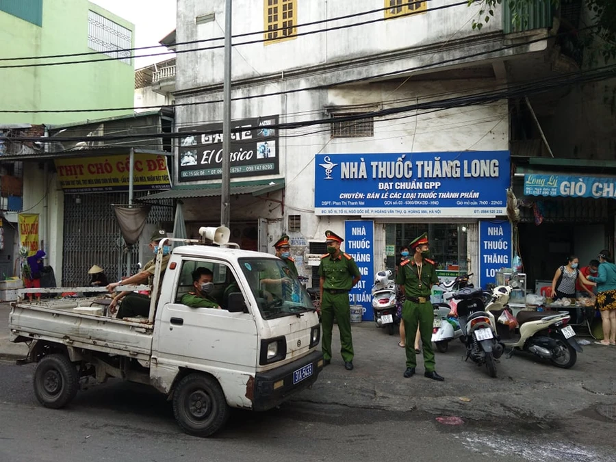 Lực lượng chức năng tuyên truyền, nhắc nhở người dân thực hiện quy định phòng dịch Covid-19.