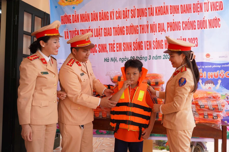 CSGT tặng áo phao và phần quà nhỏ đến các em học sinh làng chài ven sông.