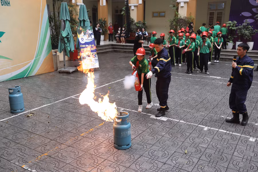 Học sinh trường THCS Nguyễn Tri Phương sử dụng bình cứu hỏa dập tắt đám cháy khí gas.