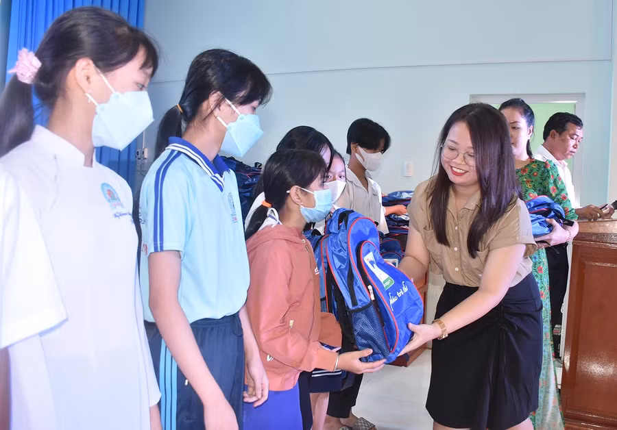 Bà Lê Thị Minh Trí (Công ty TNHH Bảo mật Nam Trường Sơn) trao quà cho các em HS.