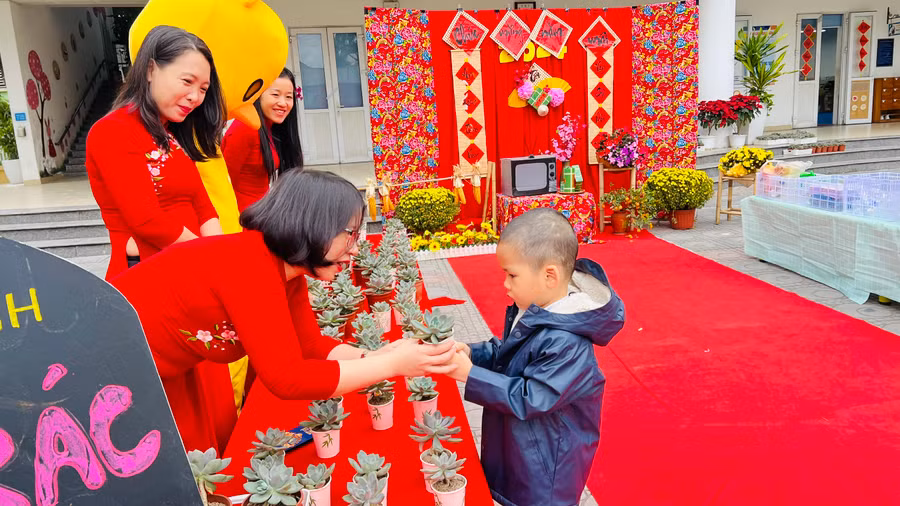 Cô Nguyễn Thị Bích Ngọc, Hiệu trưởng Trường Mầm non Tân Mai đã có mặt từ sớm ở cổng trường để đón trẻ và tự tay mình mừng tuổi trẻ những chậu cây sen đá với thông điệp mong các con ý thức bảo vệ môi trường.