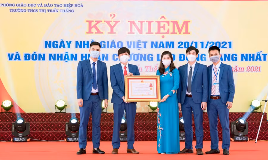 Thừa ủy quyền của Chủ tịch nước, bà Lâm Thị Hương Thành trao Huân chương Lao động hạng Nhất cho Nhà trường.