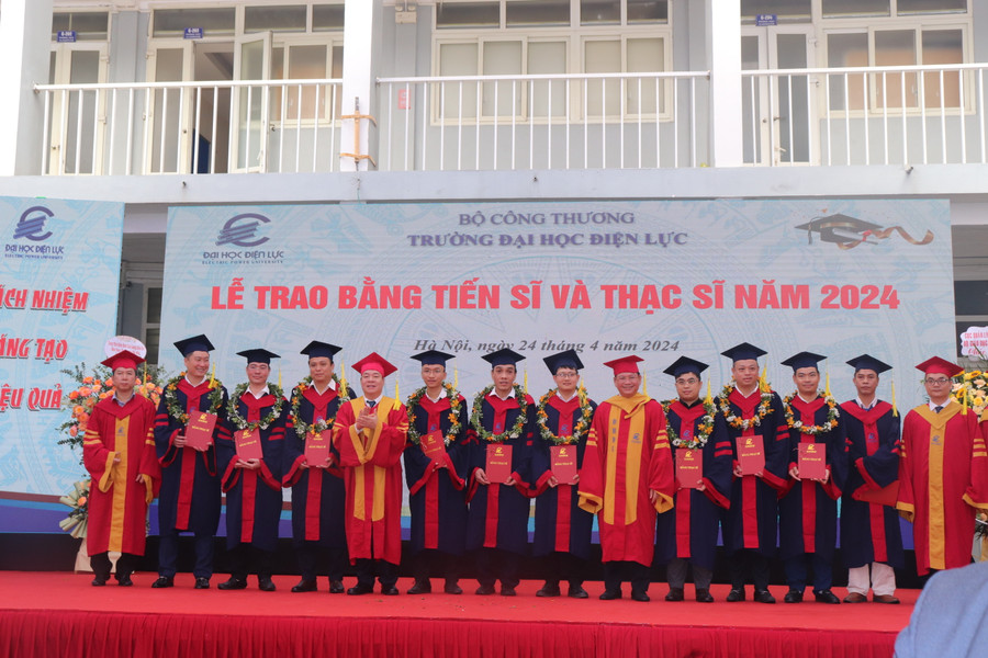 PGS.TS Vũ Đình Ngọ (thứ 5 từ trái sang) - Chủ tịch Hội đồng trường và PGS.TS Đinh Văn Châu (thứ thứ 6 từ phải sang) - Hiệu trưởng trường Đại học Điện lực cùng lãnh đạo khoa của nhà trường trao bằng, chúc mừng các tân Thạc sĩ.