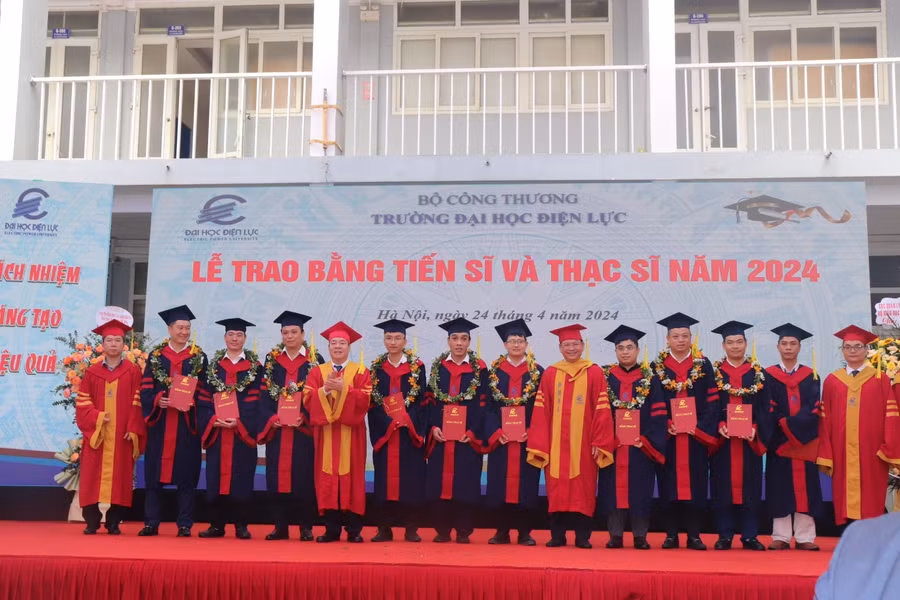 PGS.TS Vũ Đình Ngọ (thứ 5 từ trái sang) - Chủ tịch Hội đồng trường và PGS.TS Đinh Văn Châu (thứ thứ 6 từ phải sang) - Hiệu trưởng trường Đại học Điện lực cùng lãnh đạo khoa của nhà trường trao bằng, chúc mừng các tân Thạc sĩ.