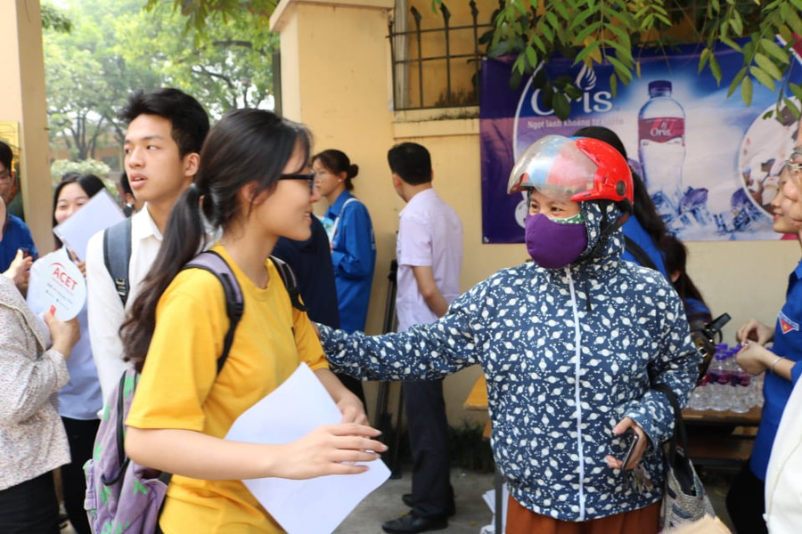 Phụ huynh nhắc nhở thí sinh chuẩn bị, kiểm tra kỹ các vật dụng, giấy tờ cần thiết trước khi bước vào phòng thi tại điểm thi Trường THPT Nguyễn Thị Minh Khai (Hà Nội).