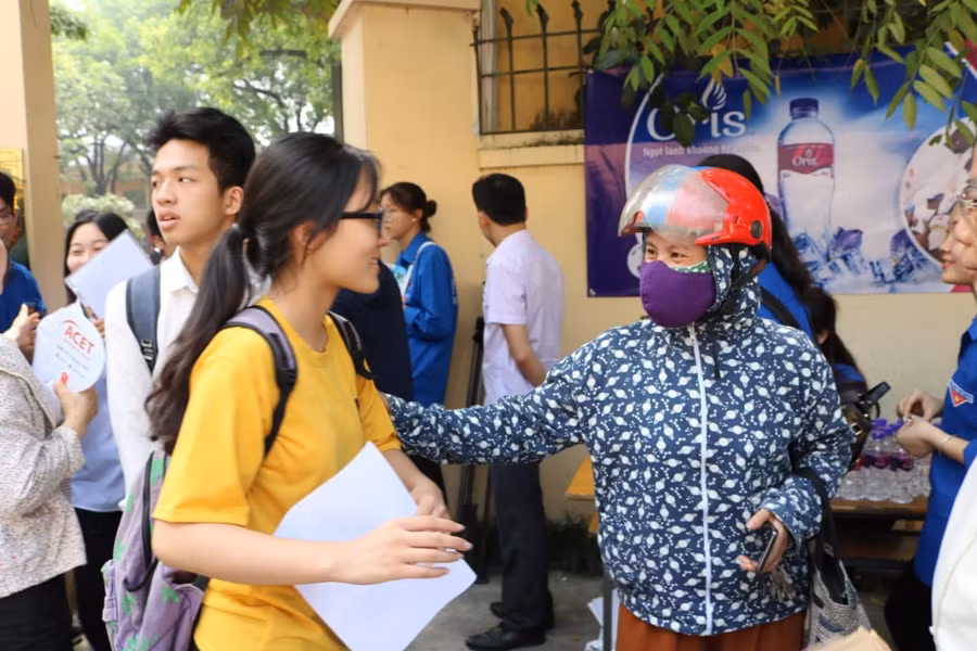 Phụ huynh nhắc nhở thí sinh chuẩn bị, kiểm tra kỹ các vật dụng, giấy tờ cần thiết trước khi bước vào phòng thi tại điểm thi Trường THPT Nguyễn Thị Minh Khai (Hà Nội).