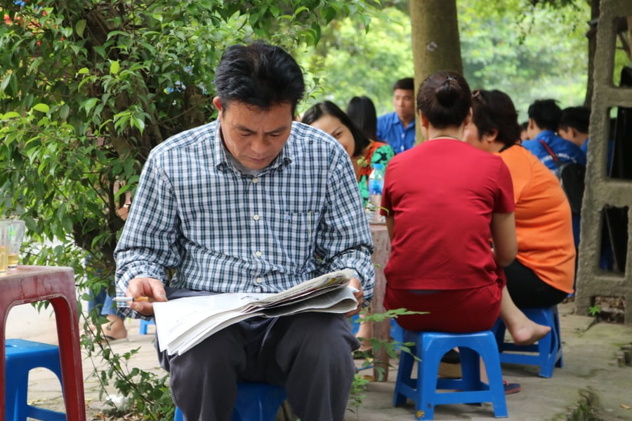 Trong thời gian chờ sĩ tử làm bài thi phụ huynh đọc báo "đốt thời gian".