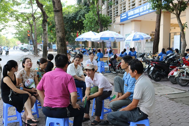 Con vào phòng thi, nhiều phụ huynh đã ở lại đợi con và "tá túc" vào các quán nước, quán cà phê hai bên đường gần điểm thi để trao đổi, bàn luận.