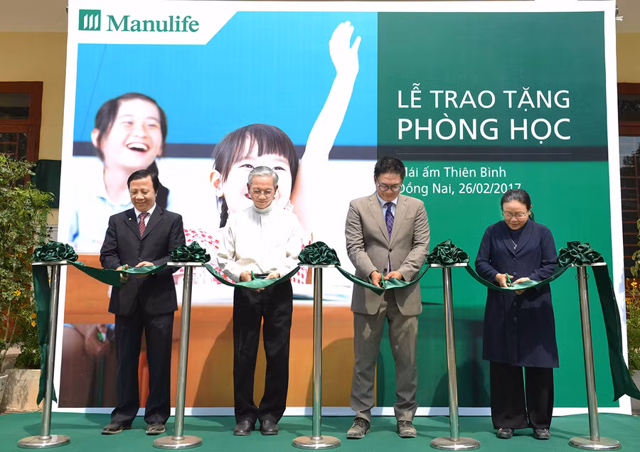 Đại diện hai đơn vị thực hiện nghi thức cắt bắng khánh thành 2 phòng học