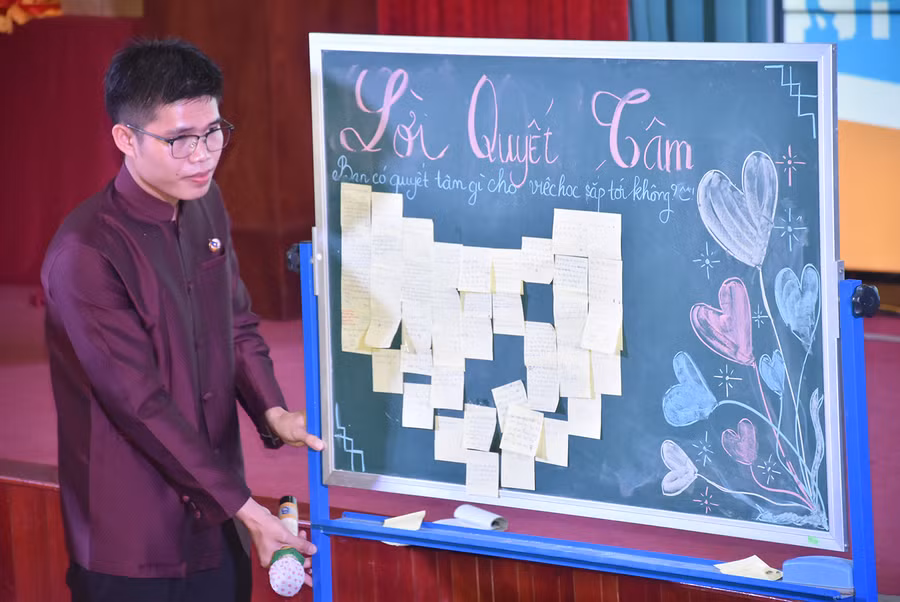 Sinh viên Lào, Campuchia thể hiện quyết tâm học tập bằng cách ghi vào tờ giấy dán lên bảng.