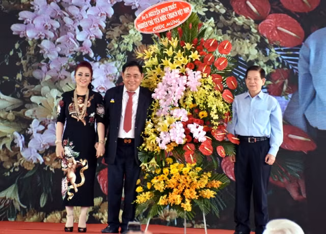 Nguyên Chủ tịch nước Nguyễn Minh Triết (phải) tặng hoa chúc mừng vợ chồng ông Huỳnh Uy Dũng