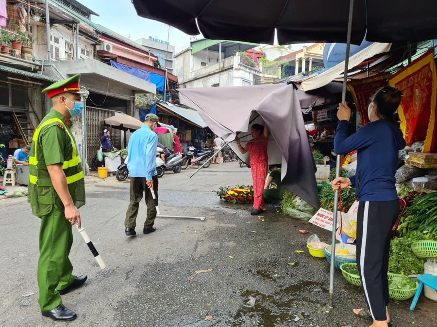 Lực lượng chức năng tuyên truyền nhắc nhở người thân thực hiện biện pháp phòng dịch Covid-19.