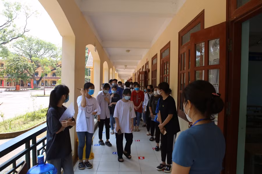 Thí sinh xếp hàng đi theo hướng dẫn của cán bộ điểm thi.