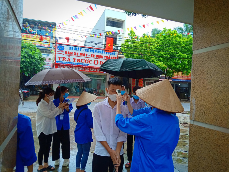 Điểm thi mưa to nhưng thí sinh không quên thực hiện nghiêm quy định phòng dịch Covid-19.
