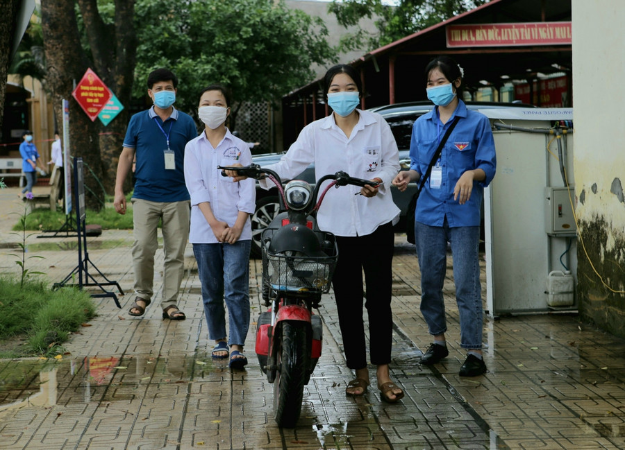 Hình ảnh thí Đồng Thị Luyến đưa bạn Ngô Thị Lan Dung (bị khuyết tật) 3 năm đến trường. Những ngày qua, Luyến miệt mài đèo bạn đến Điểm thi khiến thầy cô và thí sinh cảm phục.