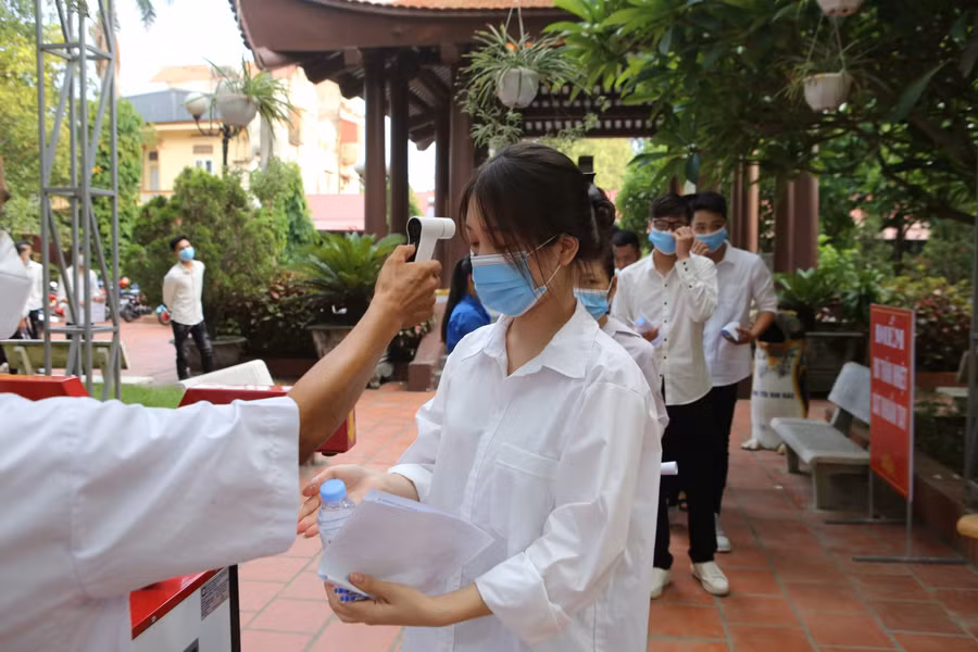 Thí sinh xếp hàng đo thân nhiệt theo quy định khi vào Điểm thi.