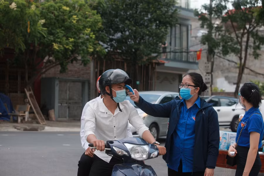 Thí sinh tại Điểm thi Trường THPT Hoàng Quốc Việt (TP Bắc Ninh) được đo thân nhiệt, nhắc nhở đeo khẩu trang.