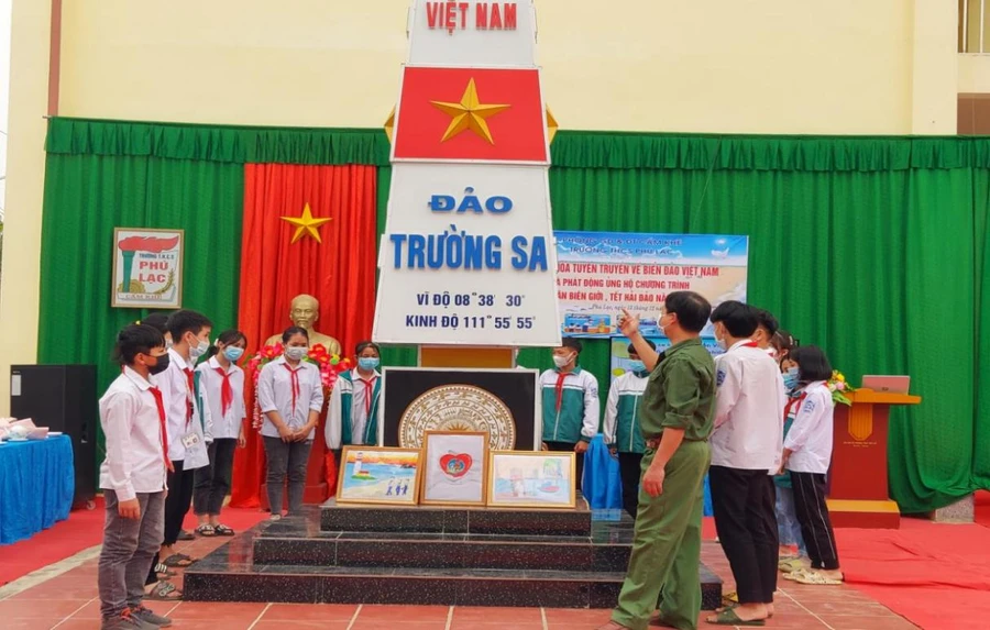 Thầy giáo, cựu chiến binh Lê Đắc Tuấn đang giới thiệu với học sinh về cột mốc chủ quyền biển, đảo Việt Nam.
