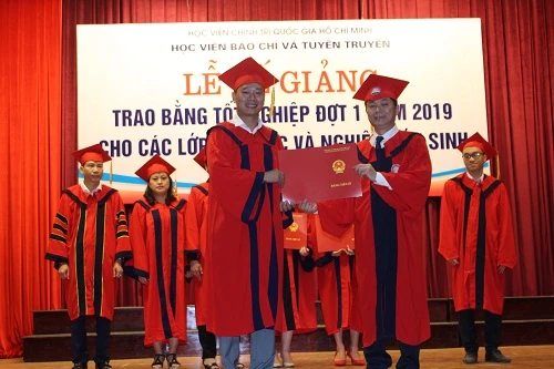 PGS, TS Phạm Minh Sơn, Phó Giám đốc Học viện Báo chí và Tuyên truyền trao bằng Tiến sĩ cho các nghiên cứu sinh tốt nghiệp.