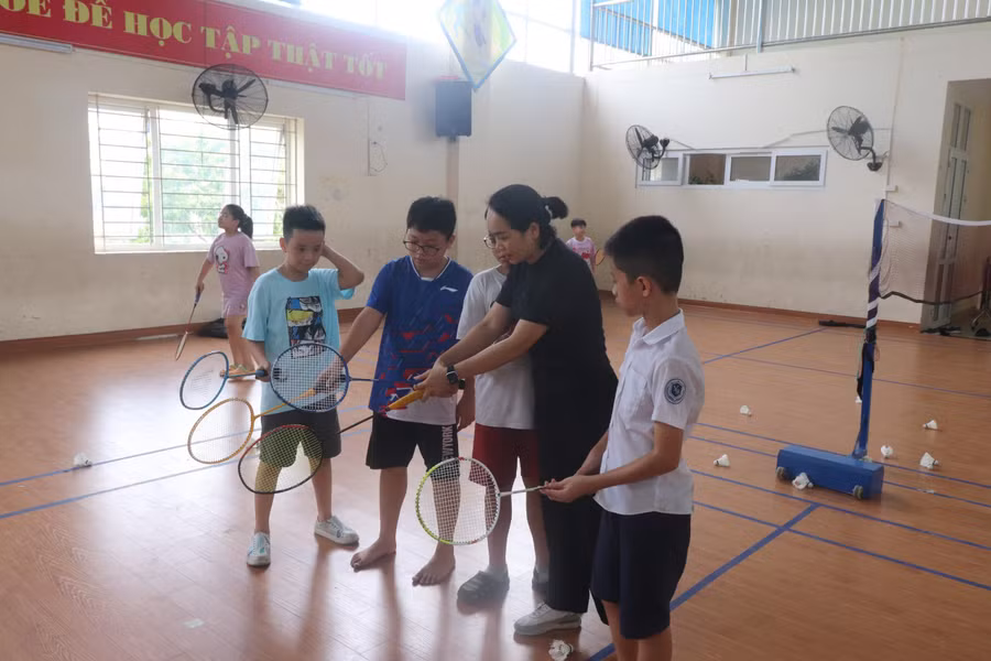 Cô giáo hướng dẫn trò với kỹ thuật môn Cầu lông.