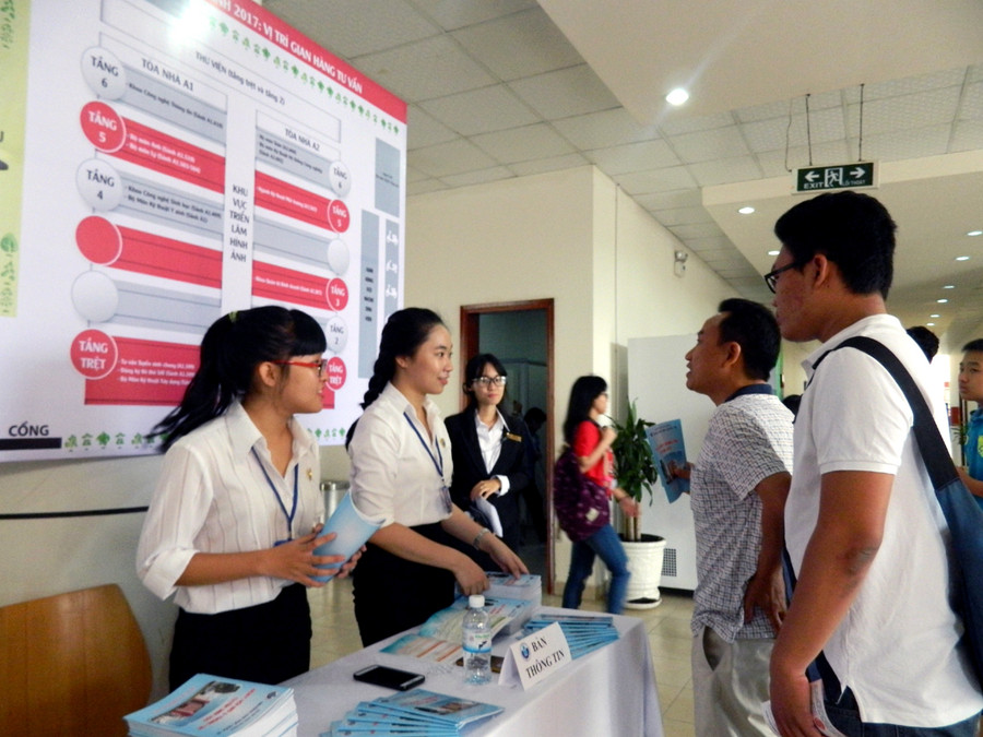 Một phụ huynh đang tìm hiểu thông tin các ngành học tại ngày hội Một phụ huynh đang tìm hiểu thông tin các ngành học tại ngày hội