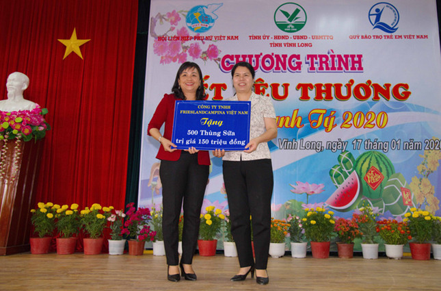 Bà Lê Thị Thúy Kiều (trái), Chủ tịch Hội LHPN tỉnh Vĩnh Long, đại diện trẻ em nghèo nhận 500 thùng sữa của Công ty FrieslandCampina Việt Nam từ bà Nguyễn Thị Tuyết Mai, Trưởng Ban Gia đình - Xã hội, Trung Ương Hội Liên Hiệp Phụ Nữ Việt Nam