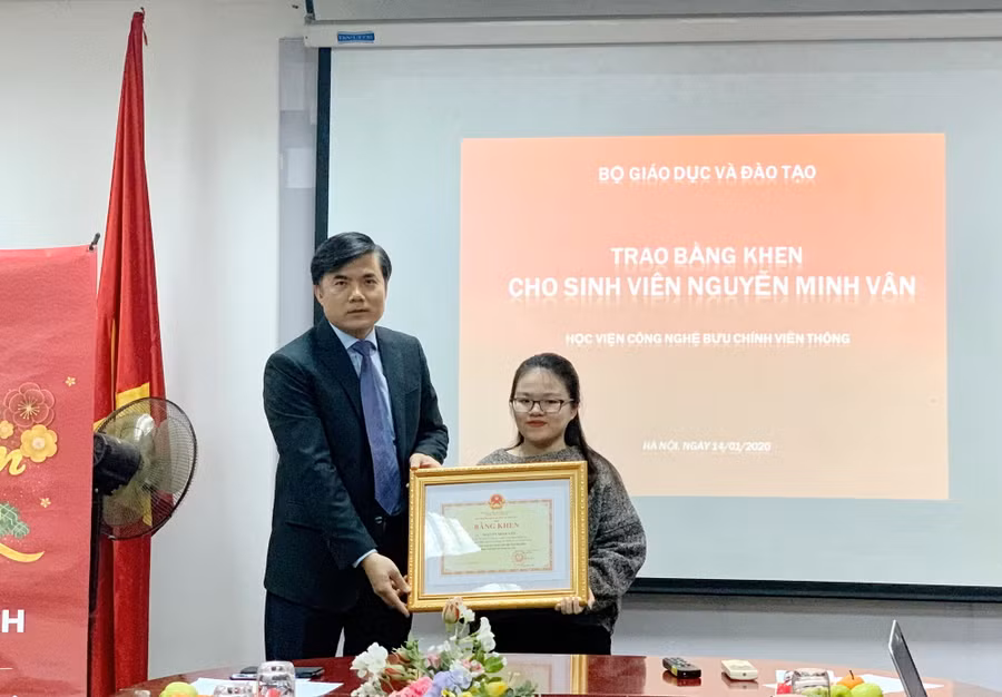 Ông Bùi Văn Linh trao bằng khen của Bộ trưởng GD&ĐT cho em Nguyễn Minh Vân.