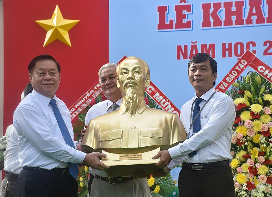 Trưởng Ban Tuyên giáo Trung ương Nguyễn Trọng Nghĩa (trái) tặng bức tượng chân dung Chủ tịch Hồ Chí Minh cho đại diện lãnh đạo Trường THPT Trương Định, Tiền Giang.