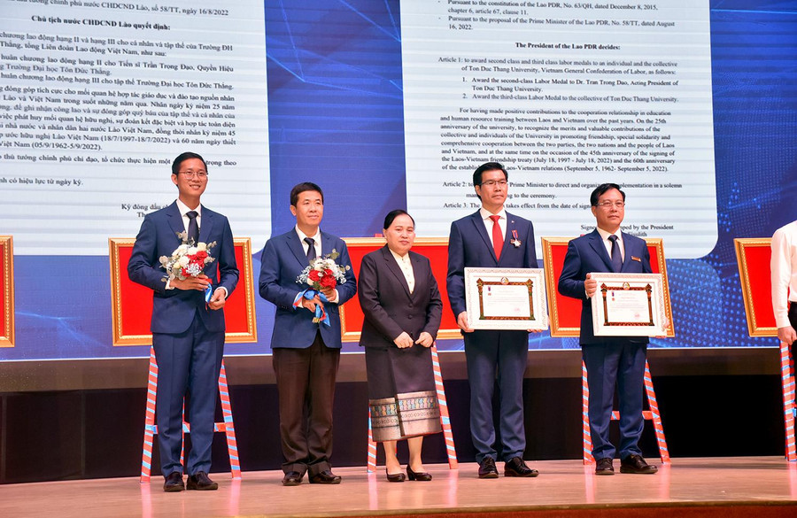 Bà Khanthaly Siriphongphanh -Thứ trưởng Bộ Giáo dục &amp; Thể thao nước CHDCND Lào, trao Huân chương Lao động hạng III cho đại diện TDTU và Huân chương lao động hạng II cho TS Trần Trọng Đạo – Quyền Hiệu trưởng TDTU.