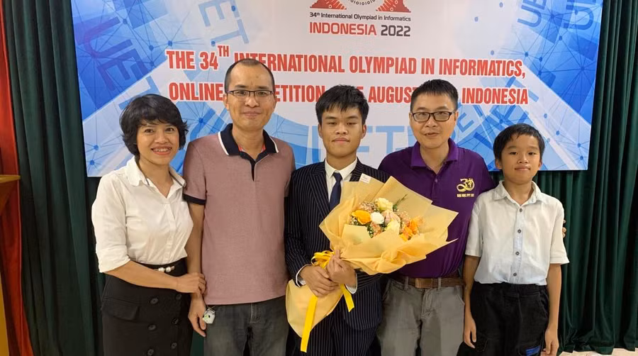 Trần Xuân Bách chụp ảnh cùng gia đình và thầy giáo ở lễ bế mạc kỳ thi Olympic Tin học quốc tế. Ảnh nhân vật cung cấp.