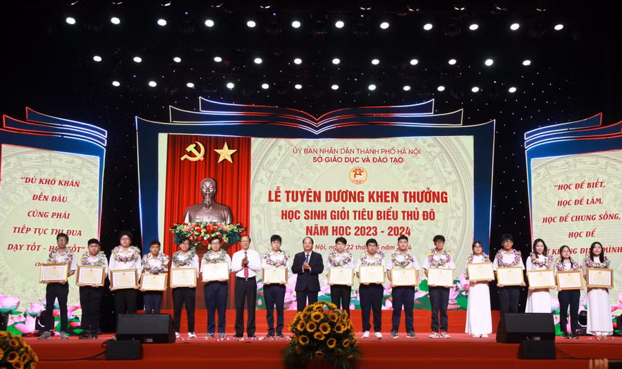 Thứ trưởng Phạm Ngọc Thưởng và Trưởng ban Tuyên giáo Thành ủy Hà Nội Nguyễn Doãn Toản tặng bằng khen của Bộ trưởng Bộ GD&amp;ĐT cho các học sinh.