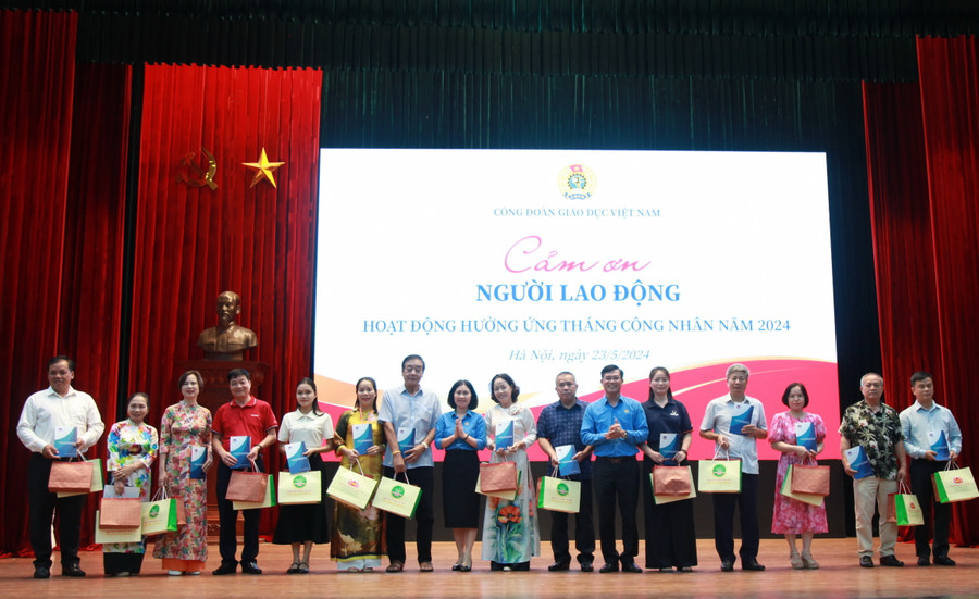 Phó Chủ tịch Công đoàn Giáo dục Việt Nam Lê Thị Mai Oanh trao quà cho các nhân viên trường học.