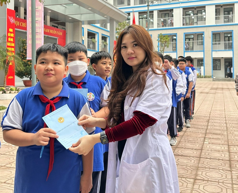 Cô Kim Ngân - cán bộ y tế của Trường THCS Thành Công hướng dẫn lại các con cách sử dụng sổ khám sức khỏe.