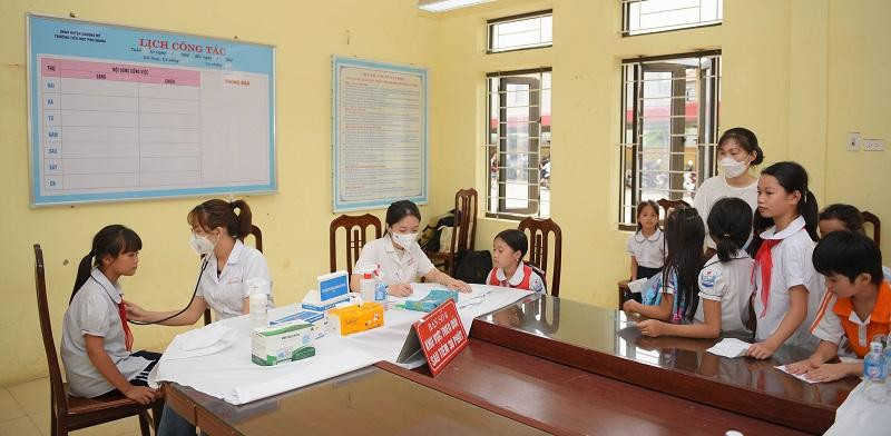 Đội ngũ y bác sĩ bệnh viện E kiểm tra sức khỏe cho học sinh. Ảnh Thế Đại.