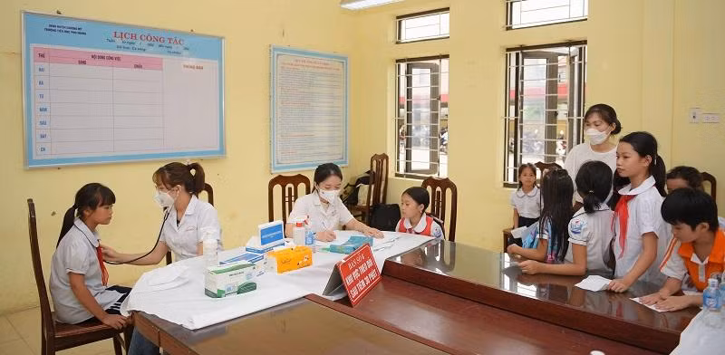 Đội ngũ y bác sĩ bệnh viện E kiểm tra sức khỏe cho học sinh. Ảnh Thế Đại.