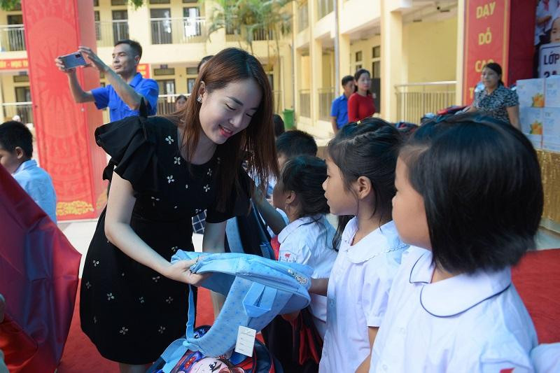 Bà Mã Thị Hồng Nhung, Giám đốc Công ty TNHH Y học Tự nhiên Frigate trao quà cho học sinh. Ảnh Thế Đại.