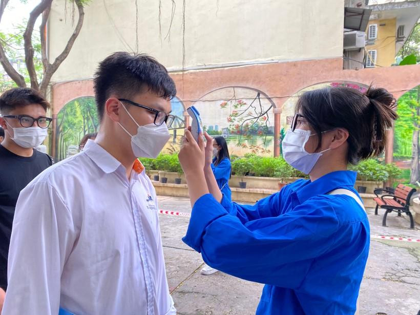 Tình nguyện viên hỗ trợ đo thân nhiệt cho thí sinh. Ảnh NC. Tình nguyện viên hỗ trợ đo thân nhiệt cho thí sinh. Ảnh NC.