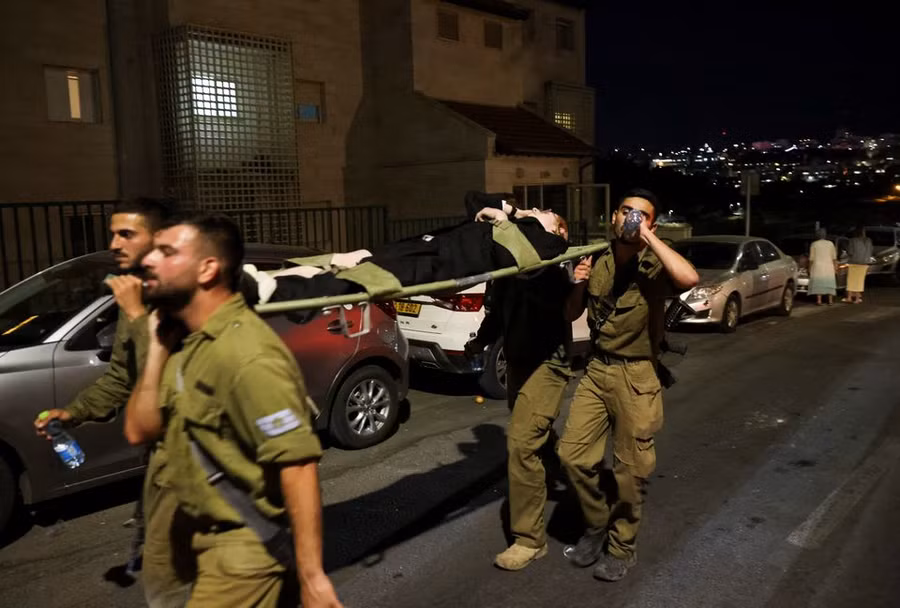 Các nhân viên quân đội quân đội khiêng một người bị thương khi khán đài tại một giáo đường Do thái đổ sập.