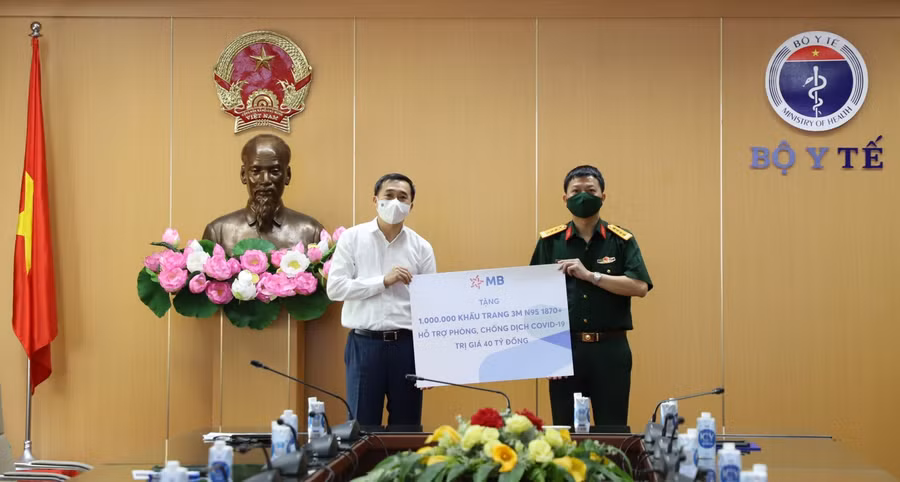 GS. TS Trần Văn Thuấn – Thứ trưởng Bộ Y tế (bên trái) tiếp nhận món quà từ MB.