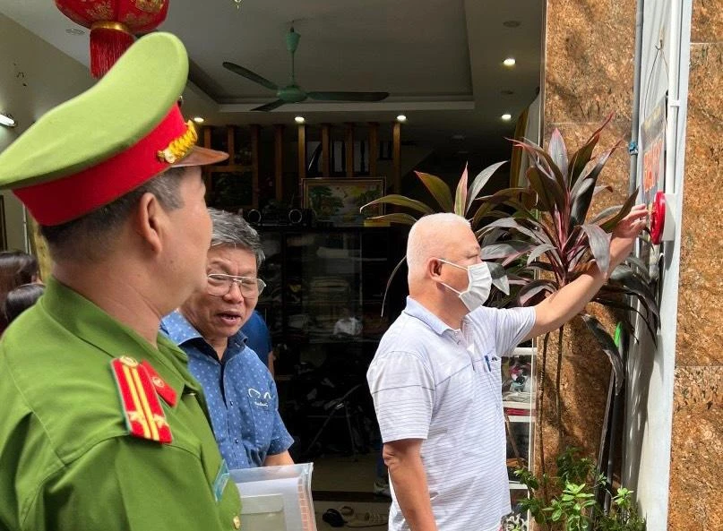 Công an hướng dẫn người dân thực hiện vận hành chuông báo cháy.