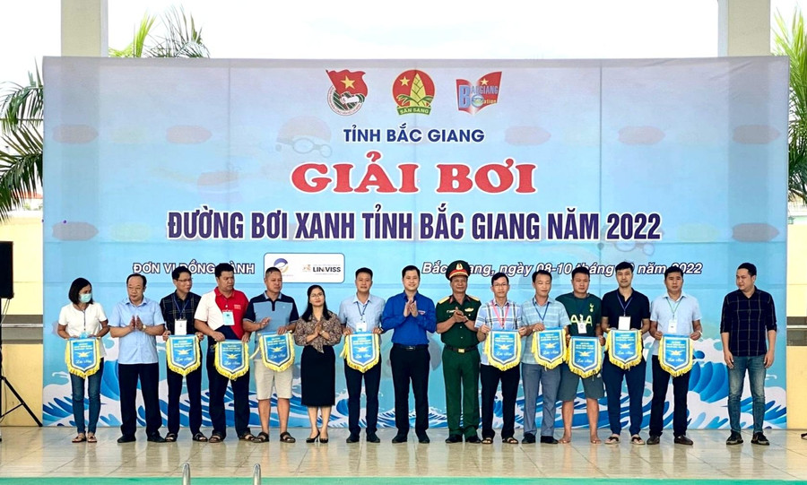 Ban tổ chức tặng cờ lưu niệm cho các đơn vị tham gia giải bơi.