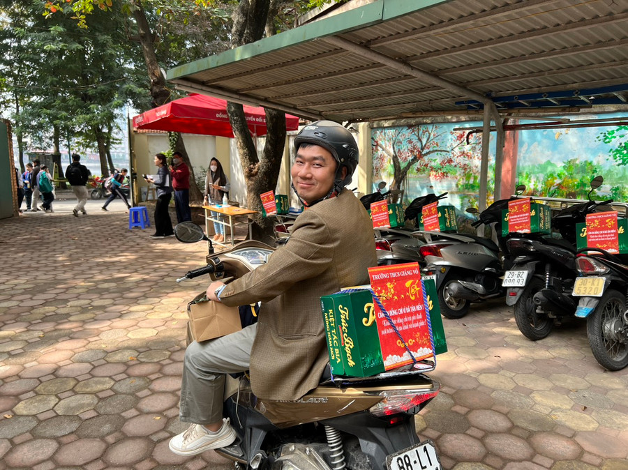 Thầy Nguyễn Ngọc Hân - giáo viên Toán (trường THCS Giảng Võ) vui mừng với phần quà trên xe.
