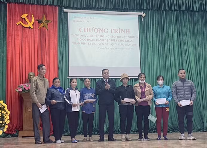 Ông Nguyễn Văn Thêm - Phó Giám đốc Sở GD&ĐT tặng quà cho đại diện các hộ gia đình chính sách, hộ nghèo trên địa bàn xã Trường Sơn.