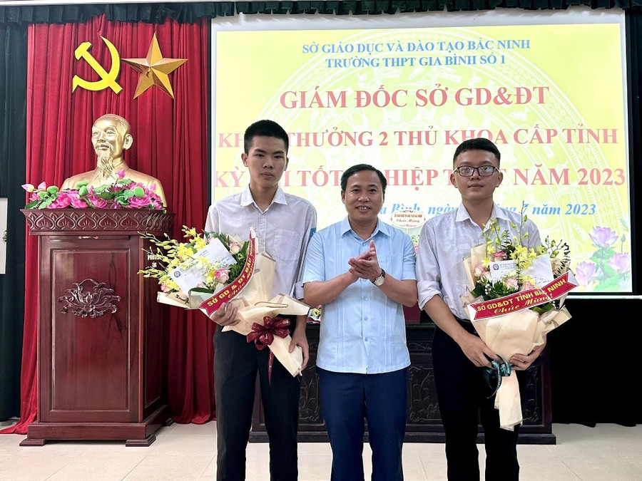 Ông Nguyễn Hữu Bình - Phó Giám đốc GD&ĐT Bắc Ninh tặng hoa chúc mừng 2 thủ khoa Lê Đình Sáng và Nguyễn Khắc Thái.