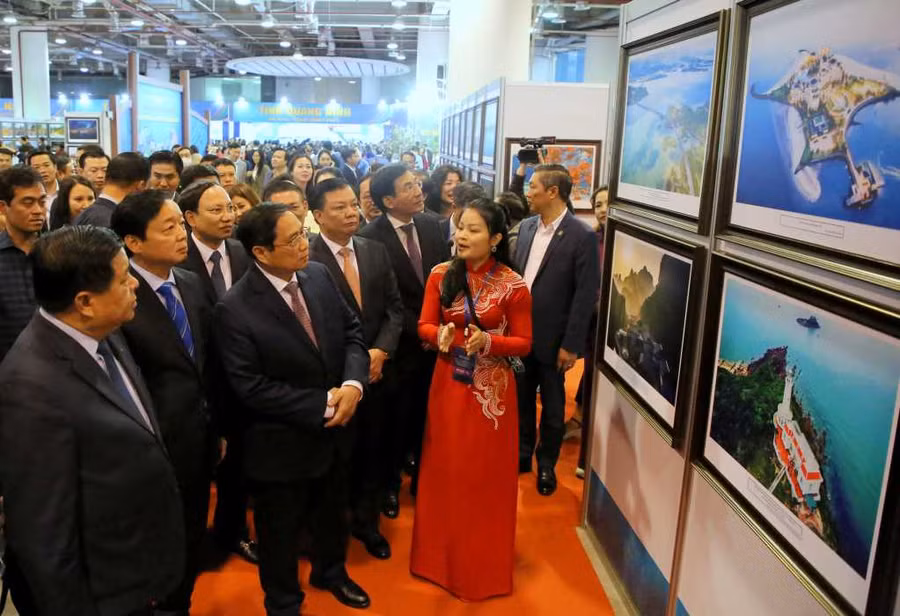 Thủ tướng Phạm Minh Chính nghe giới thiệu những bức ảnh đẹp về thiên nhiên, văn hóa, con người tỉnh Quảng Ninh.