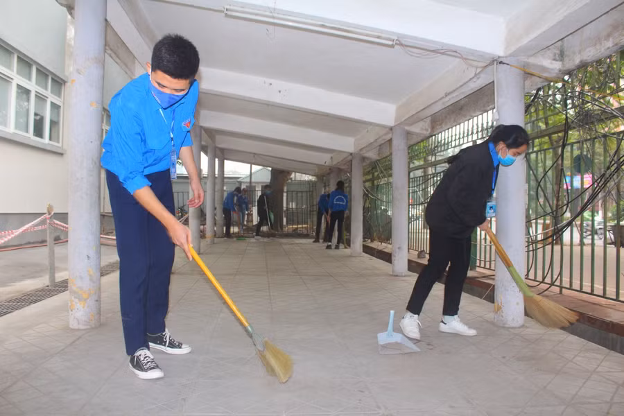 Sinh viên quét dọn vệ sinh môi trường khu để xe.