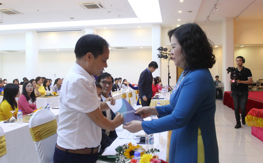 Thứ trưởng Ngô Thị Minh tặng quà cho giáo viên đặc biệt là nhân vật trong tác phẩm đạt giải.