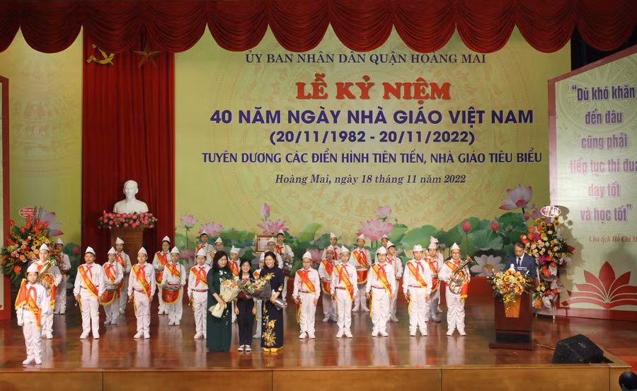 Đại diện học sinh tặng hoa chúc mừng các thầy cô giáo trong quận.